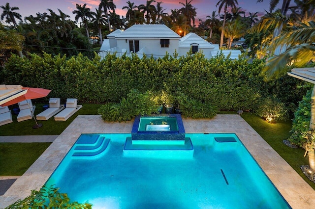 view of swimming pool featuring a patio area, a lawn, and a pool with connected hot tub