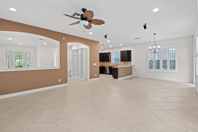 unfurnished living room with light tile patterned flooring and ceiling fan with notable chandelier