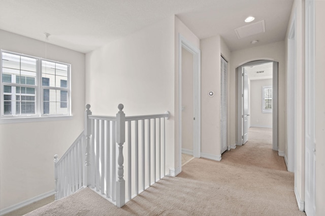 corridor featuring light colored carpet