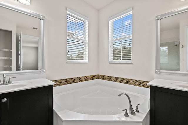 bathroom with vanity and shower with separate bathtub