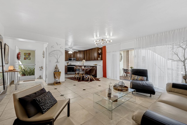 living room featuring light tile patterned flooring, ceiling fan with notable chandelier, and a healthy amount of sunlight