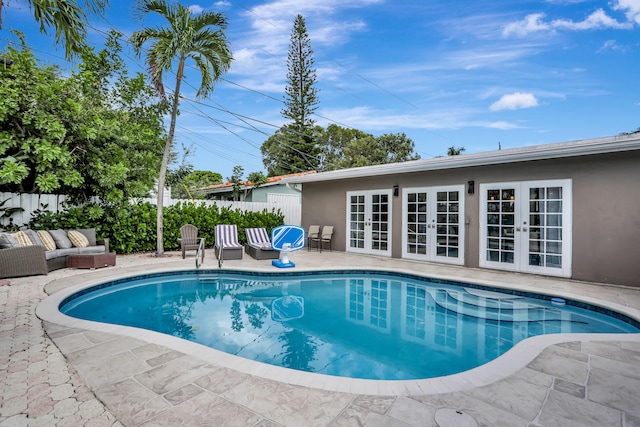 view of swimming pool with a patio and french doors