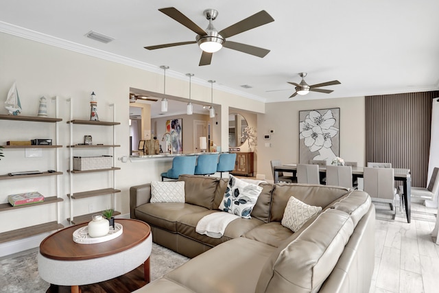 living room featuring ceiling fan, crown molding, sink, and light wood-type flooring