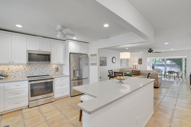 kitchen featuring appliances with stainless steel finishes, ceiling fan, white cabinetry, and light tile patterned floors