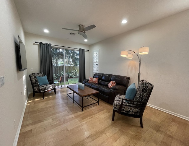 living room with ceiling fan and light hardwood / wood-style flooring