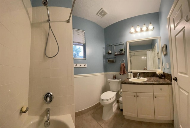 328 SE Bloxham Way, Stuart, FL 34997 - bathroom featuring toilet, vanity,  shower combination, tile patterned floors, and a wainscoted wall