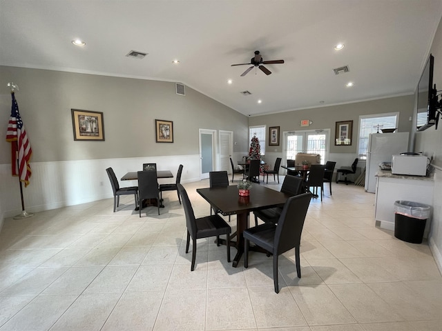 dining room with ceiling fan, light tile patterned flooring, vaulted ceiling, and ornamental molding