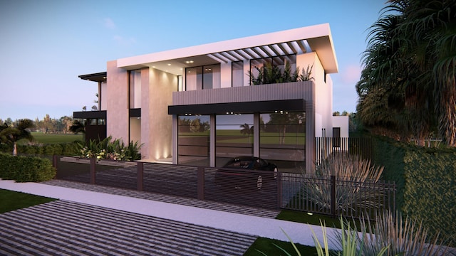 back of property featuring fence, a balcony, and stucco siding