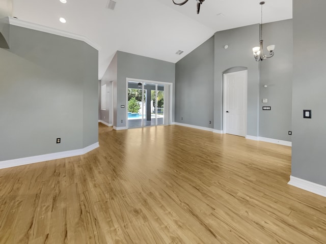 unfurnished living room featuring high vaulted ceiling, a chandelier, and light hardwood / wood-style floors