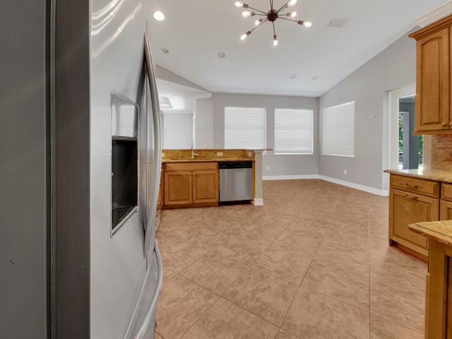 kitchen with a notable chandelier, vaulted ceiling, appliances with stainless steel finishes, and light tile patterned floors