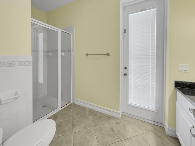 bathroom featuring tile patterned floors, a shower with shower door, toilet, and vanity