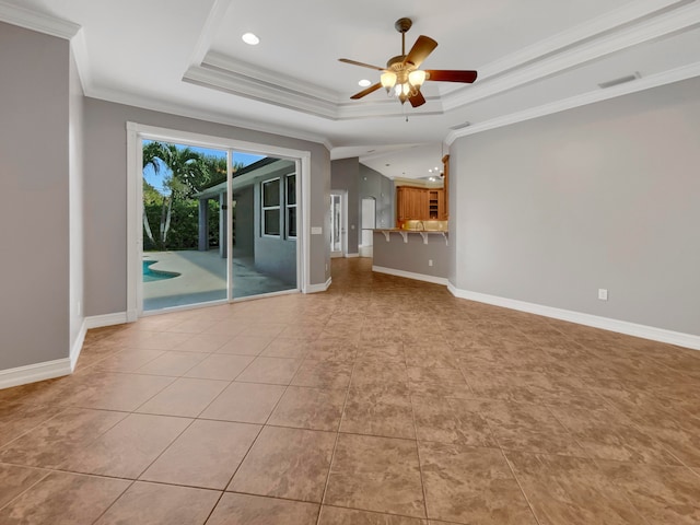 unfurnished living room featuring light tile patterned flooring, ceiling fan, a raised ceiling, and ornamental molding