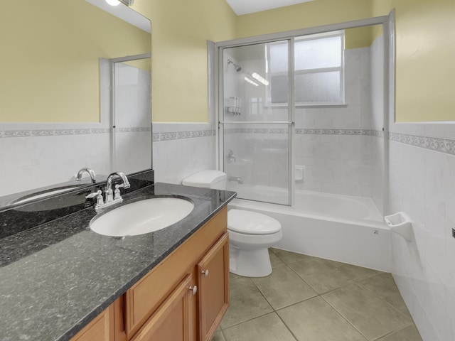 full bathroom featuring tile walls, vanity, tile patterned flooring, toilet, and enclosed tub / shower combo