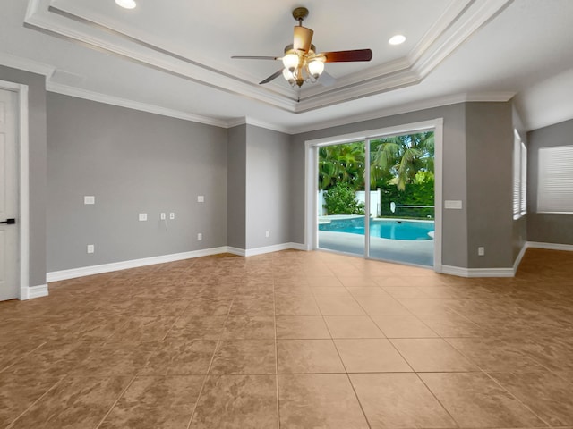 tiled spare room with ceiling fan, a raised ceiling, and ornamental molding