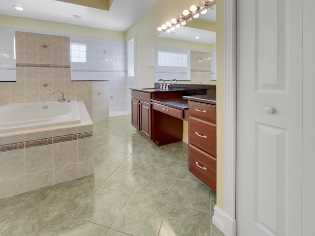 bathroom with tiled bath, tile patterned floors, and vanity