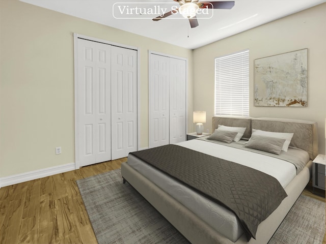 bedroom featuring hardwood / wood-style floors, ceiling fan, and two closets