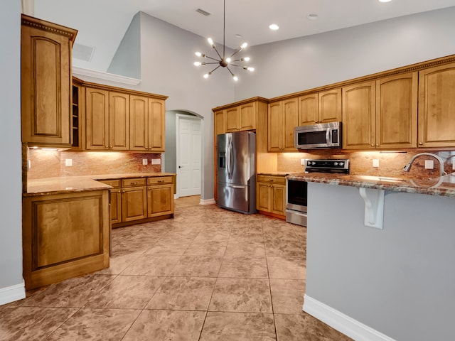 kitchen with high vaulted ceiling, light tile patterned flooring, light stone countertops, and stainless steel appliances