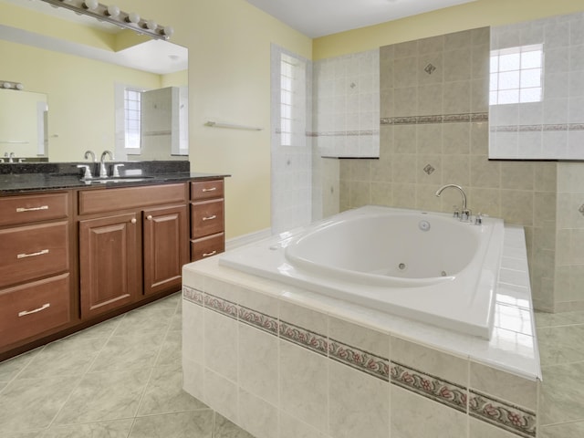 bathroom with tile patterned floors, vanity, and tiled tub