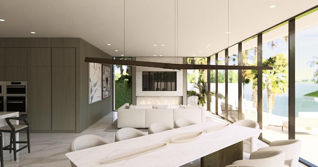 living room featuring a high ceiling, expansive windows, marble finish floor, and recessed lighting