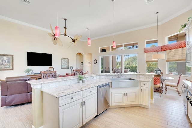 kitchen with stainless steel dishwasher, sink, crown molding, light stone countertops, and hanging light fixtures