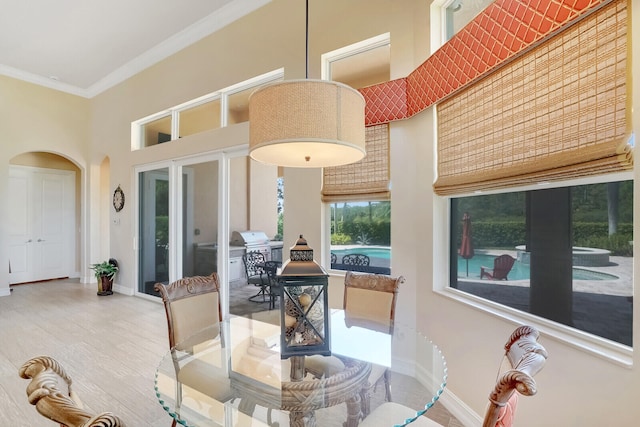 dining area featuring a towering ceiling and ornamental molding