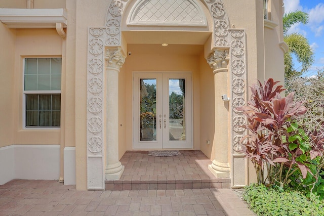 entrance to property featuring french doors and stucco siding