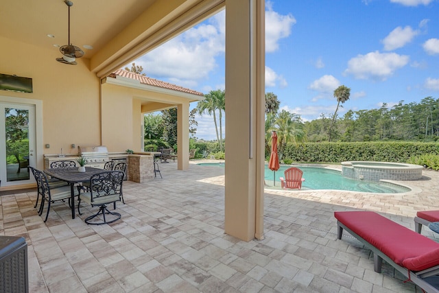 view of patio with grilling area and a swimming pool with hot tub