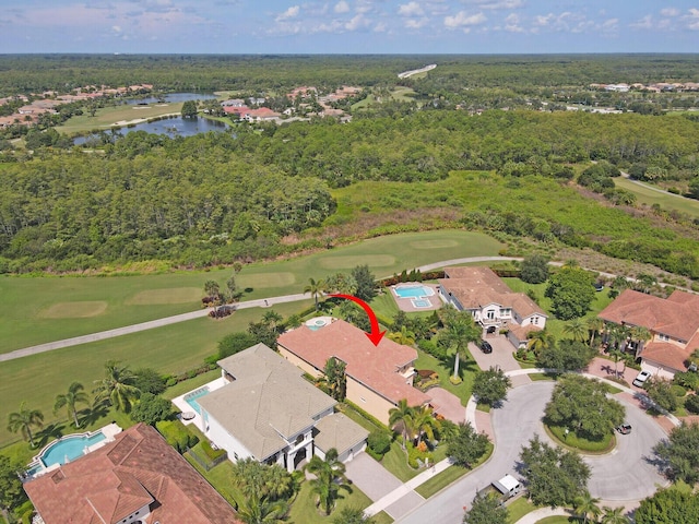 drone / aerial view with a water view and view of golf course