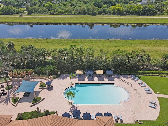 community pool featuring a water view, a patio area, and a yard