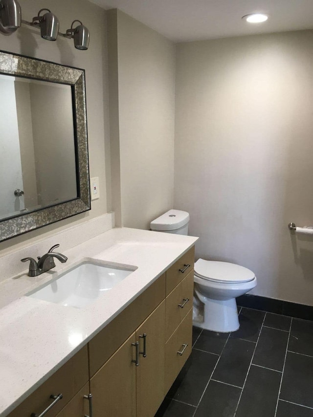 bathroom featuring toilet, vanity, and tile patterned floors