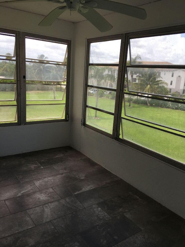 unfurnished sunroom with ceiling fan