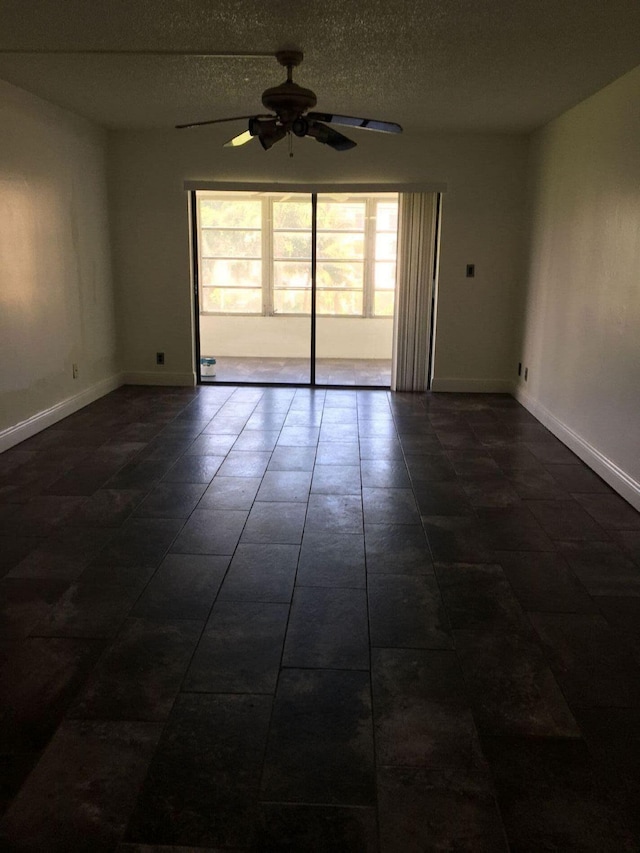 tiled empty room with a textured ceiling and ceiling fan