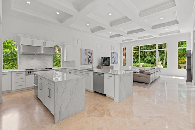 kitchen with dishwasher, coffered ceiling, beamed ceiling, light tile patterned floors, and a kitchen island