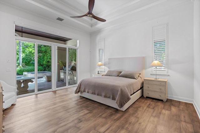 bedroom featuring ceiling fan, a raised ceiling, ornamental molding, access to exterior, and hardwood / wood-style flooring