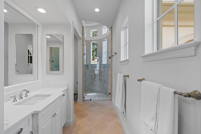 bathroom featuring tile patterned flooring, a shower with door, and vanity