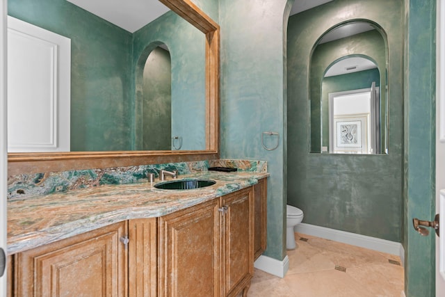 bathroom featuring tile patterned flooring, toilet, and vanity