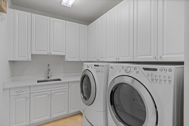 laundry area with sink, light tile patterned floors, cabinets, and independent washer and dryer