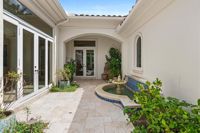 property entrance featuring a patio and french doors