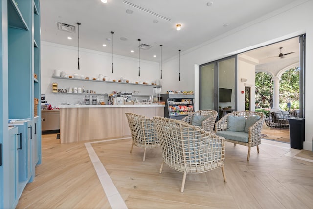 dining space with light parquet flooring, ornamental molding, and ceiling fan