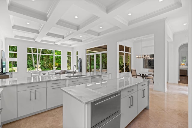 kitchen featuring sink, light tile patterned flooring, a healthy amount of sunlight, and coffered ceiling