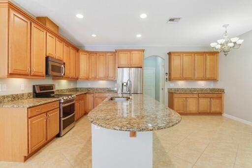 kitchen featuring a chandelier, a kitchen island with sink, decorative light fixtures, stainless steel appliances, and light tile patterned flooring