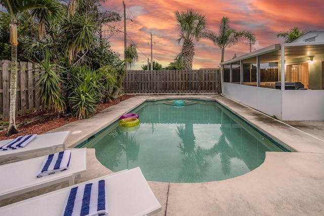 pool at dusk featuring a patio area