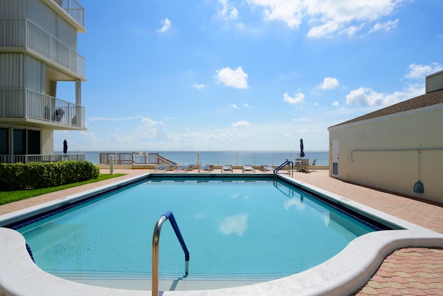 view of swimming pool featuring a water view