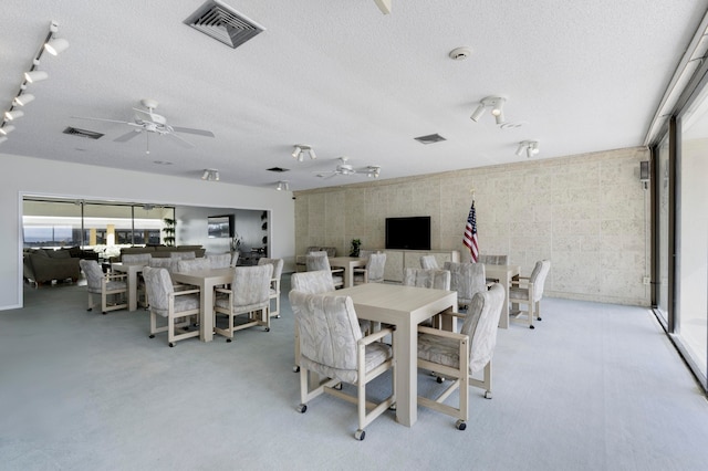 dining area featuring ceiling fan, rail lighting, and a textured ceiling