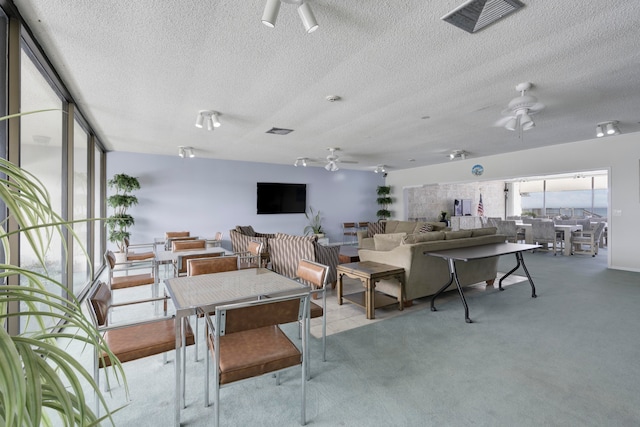 dining area with ceiling fan, light carpet, and a textured ceiling