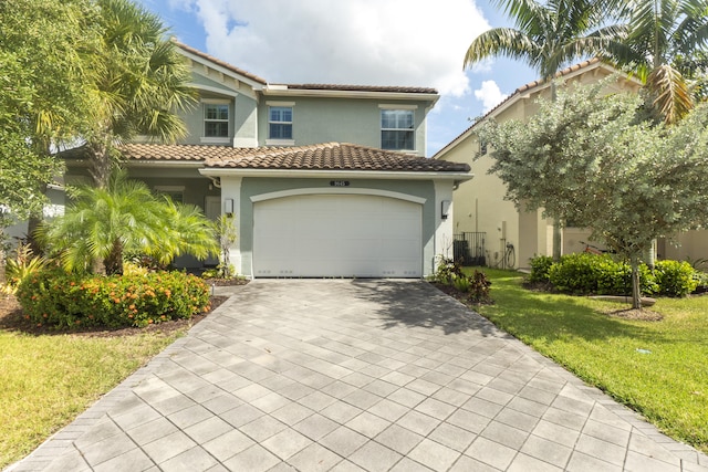 mediterranean / spanish house featuring a garage and a front lawn