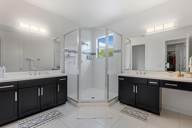 bathroom featuring tile patterned floors, a shower with door, and vanity