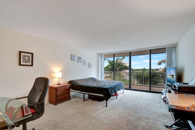 carpeted bedroom featuring a textured ceiling, expansive windows, and access to outside