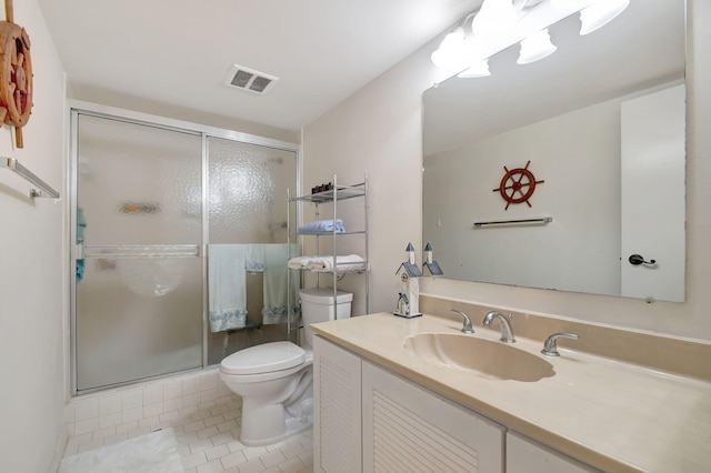 bathroom featuring tile patterned floors, a shower with door, vanity, and toilet