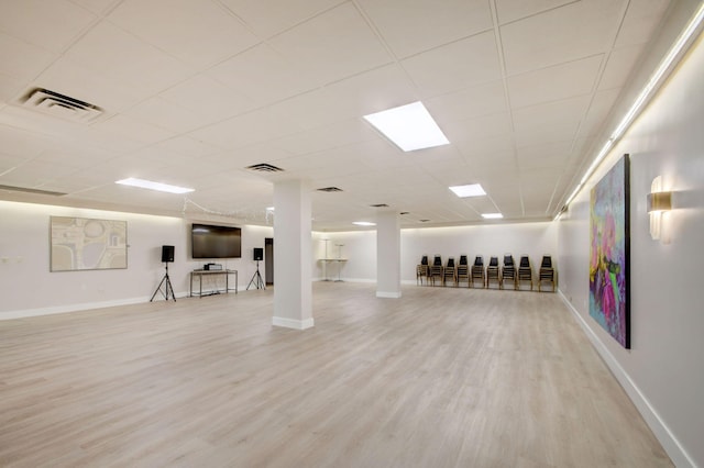 basement featuring light hardwood / wood-style floors and a paneled ceiling